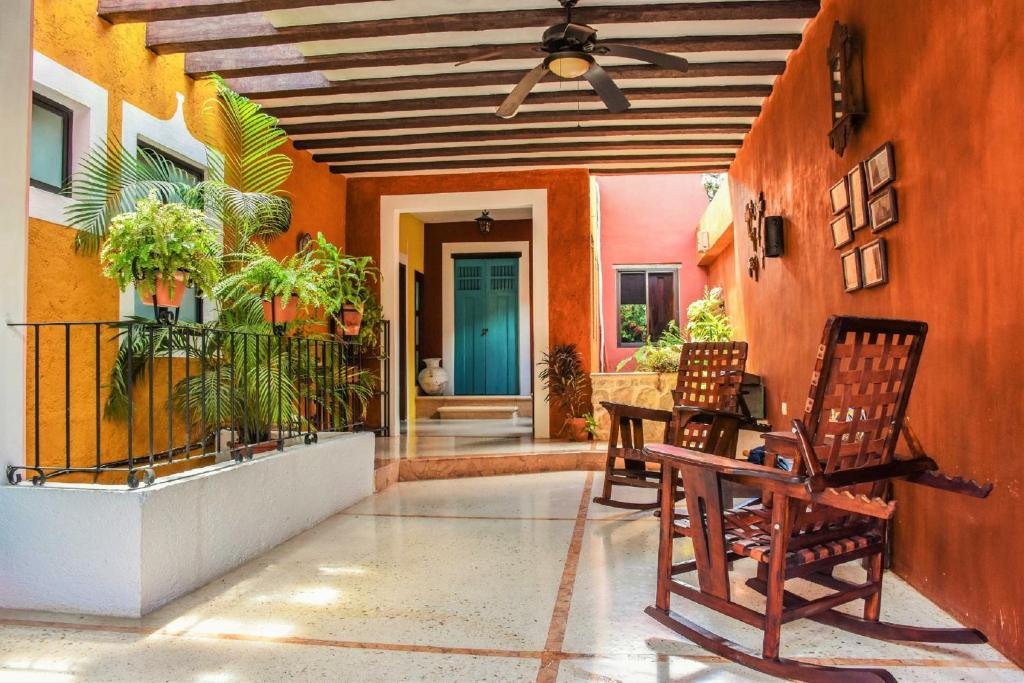 um alpendre com duas cadeiras, uma mesa e uma porta azul em Casa Tia Micha em Valladolid