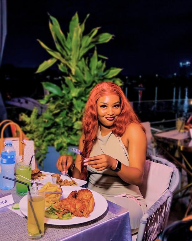 a woman sitting at a table with a plate of food at Terraform Hotel in Lagos