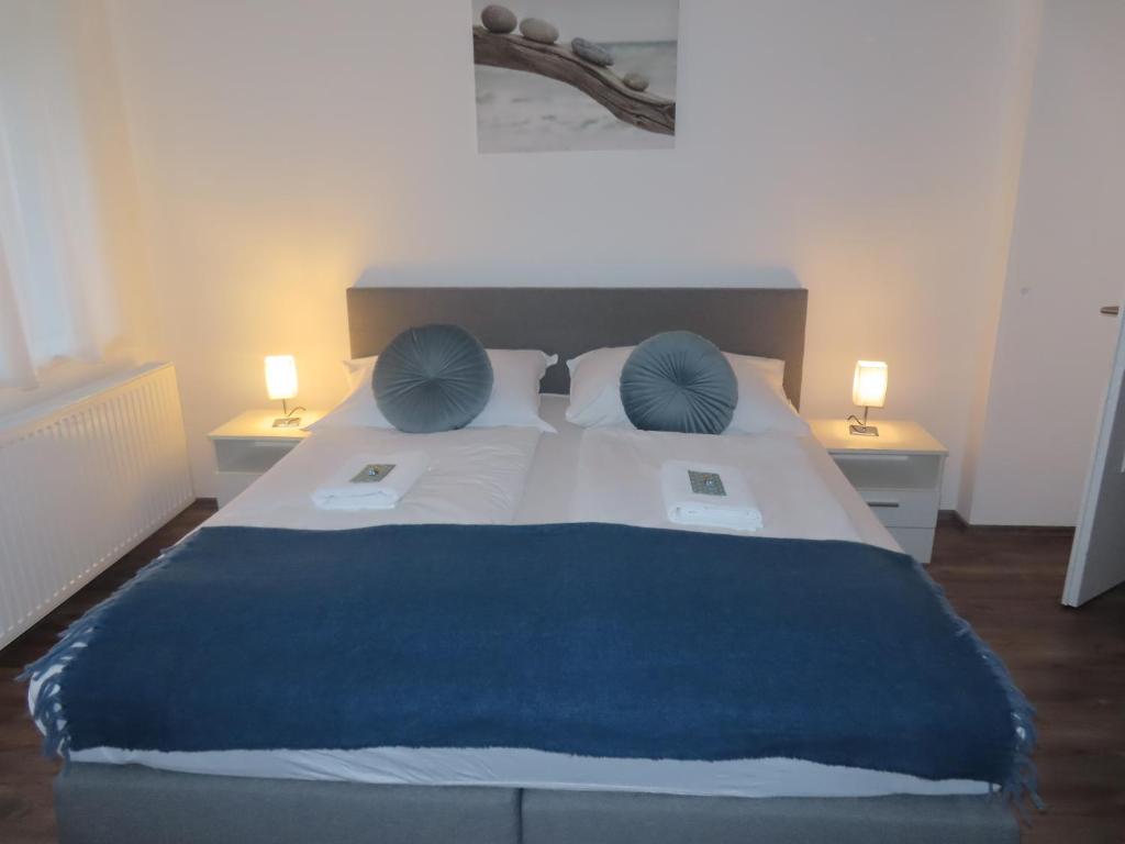 a bedroom with a large bed with blue pillows at Apartment Vlora-Naturblick in Villach