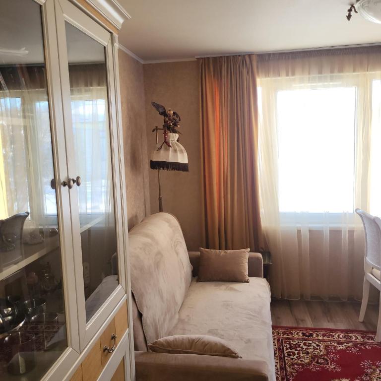 a living room with a chair and a window at House with a fireplace in Daugavpils