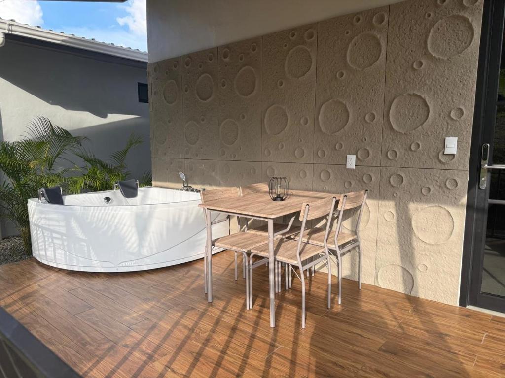a table and chairs on a deck with a bath tub at Arenal Star Luxury Studios with Private Jacuzzi in Fortuna