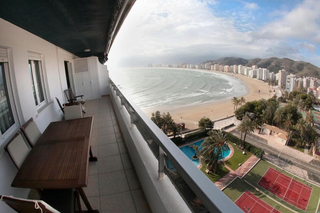 a balcony with a table and a view of the beach at Cullera - Primera Línea de Playa in Faro de Cullera