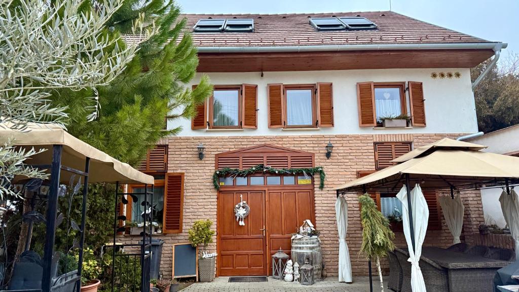 a house with a large wooden door with a bicycle in front at Atkári Vendégház in Bóly