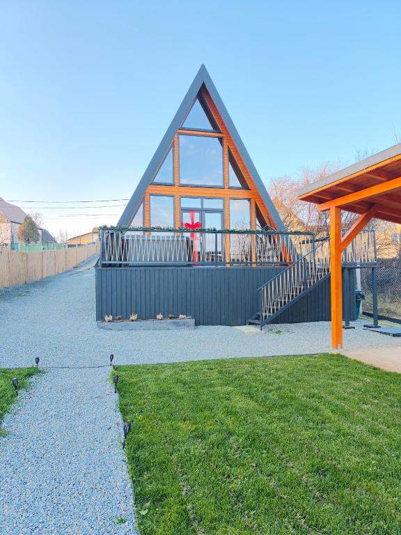 ein Haus mit einem großen Fenster an der Seite in der Unterkunft Roua A-frame in Deal