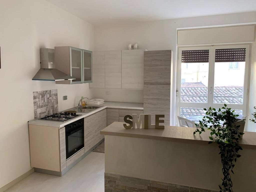 a white kitchen with a stove and a window at Casa Roncalli 19 in Foligno