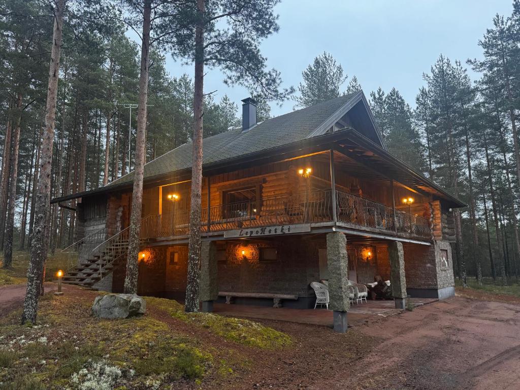 a log cabin in the woods with a deck at Lepohetki in Loimaa
