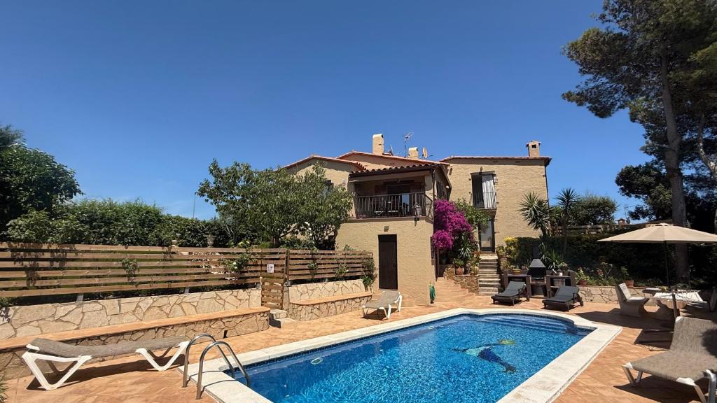 a villa with a swimming pool in front of a house at Bellavista in Begur