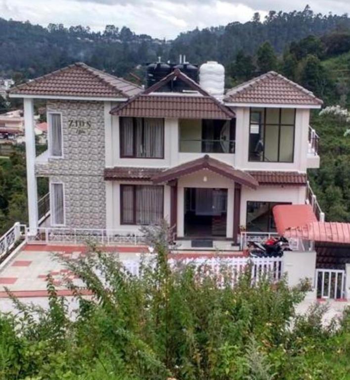 a large white house on top of a hill at Zioneliteresidency in Kodaikānāl