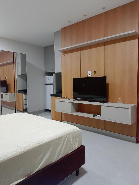 a bedroom with a bed and a flat screen tv at Residencial Ibiapaba in Camocim