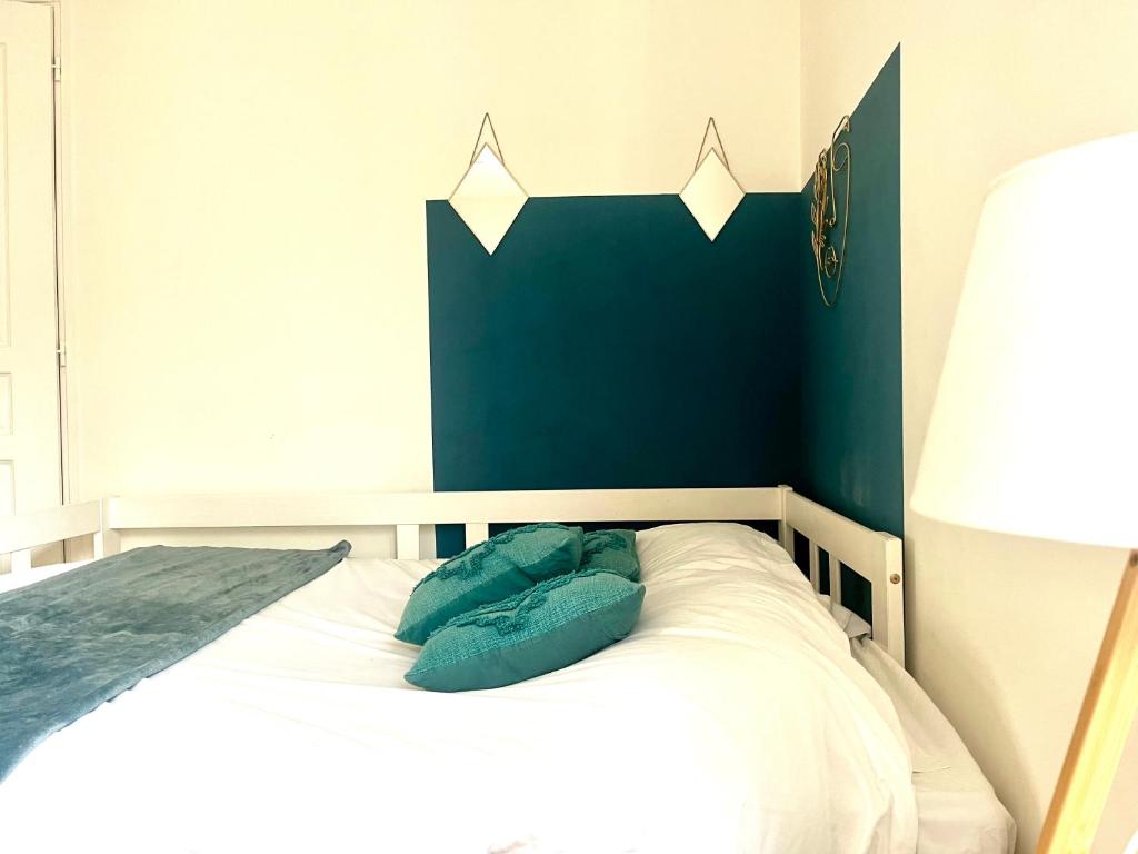 a bedroom with a bed with a blue wall at Le Blue- hyper centre ville in Sens