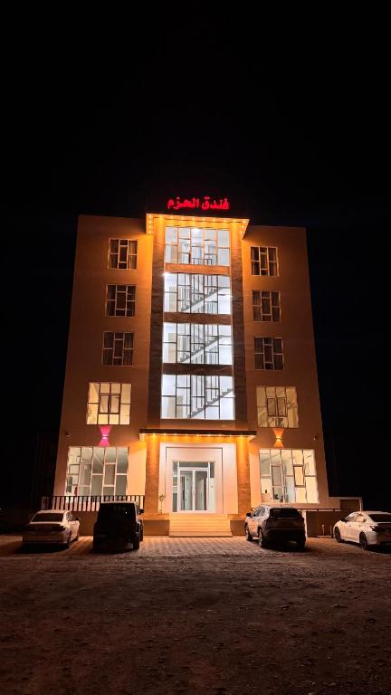 a building with cars parked in front of it at night at فندق الحزم الرستاق Alhazm Hotel Alrustaq in Ḩazm
