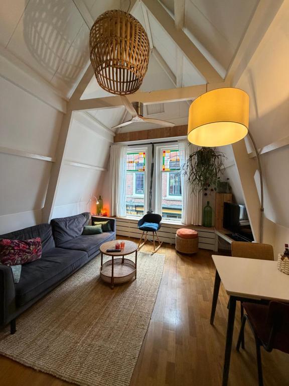 a living room with a blue couch and a table at At Loum in Alkmaar