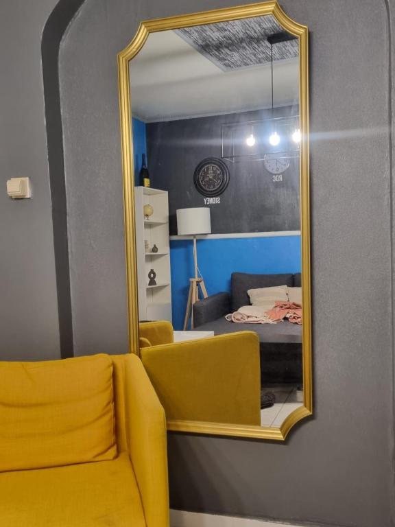 a yellow chair and a mirror in a room at Lodge Beauty & Roger in Chièvres