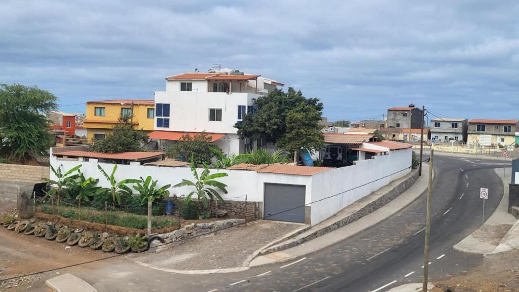 a white building on the side of a road at Hospedaria Santo António 2 in Praia Baixo