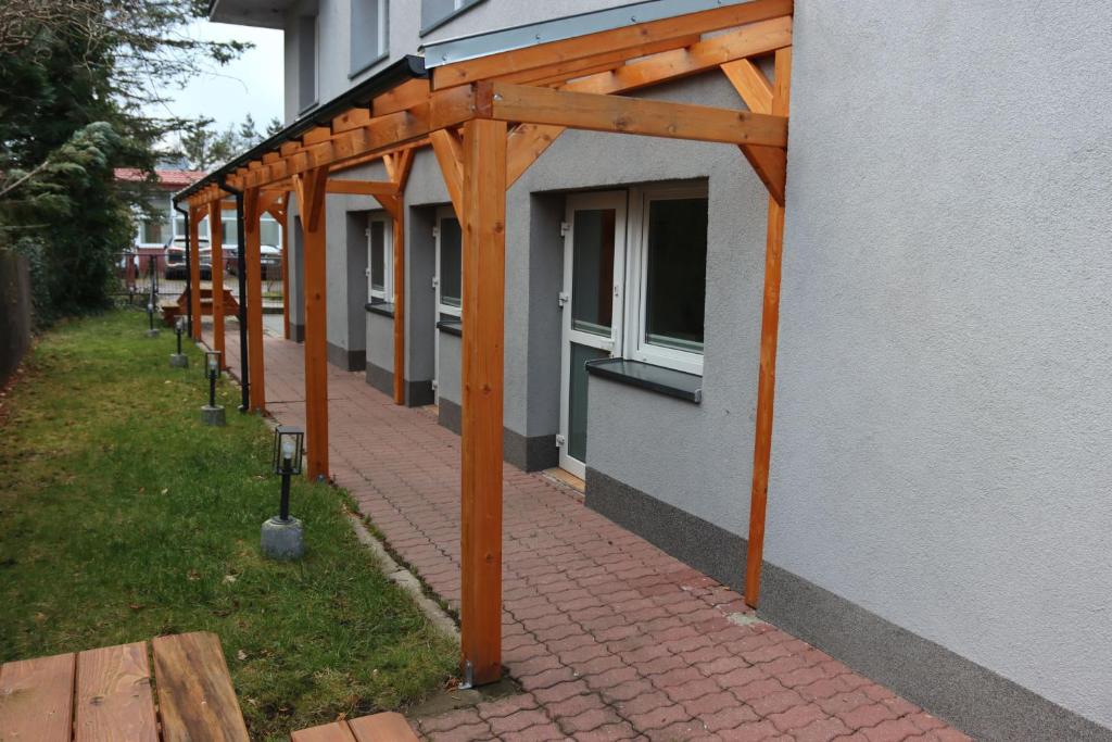 awnings on a building next to a brick sidewalk at Minuta do plaży - Sarbinowo in Sarbinowo