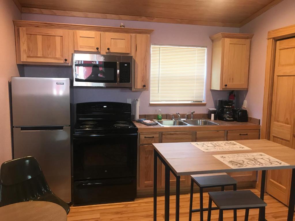 a kitchen with a stainless steel refrigerator and a table at The Red Station Apartment #1 in Columbia Falls