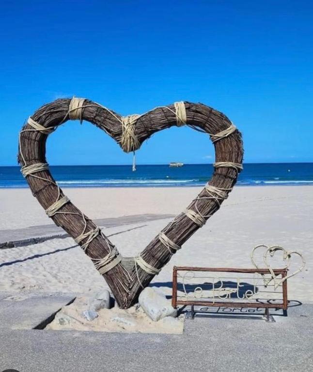 a heart sculpture on the beach next to a bench at Le face mer in Le Portel