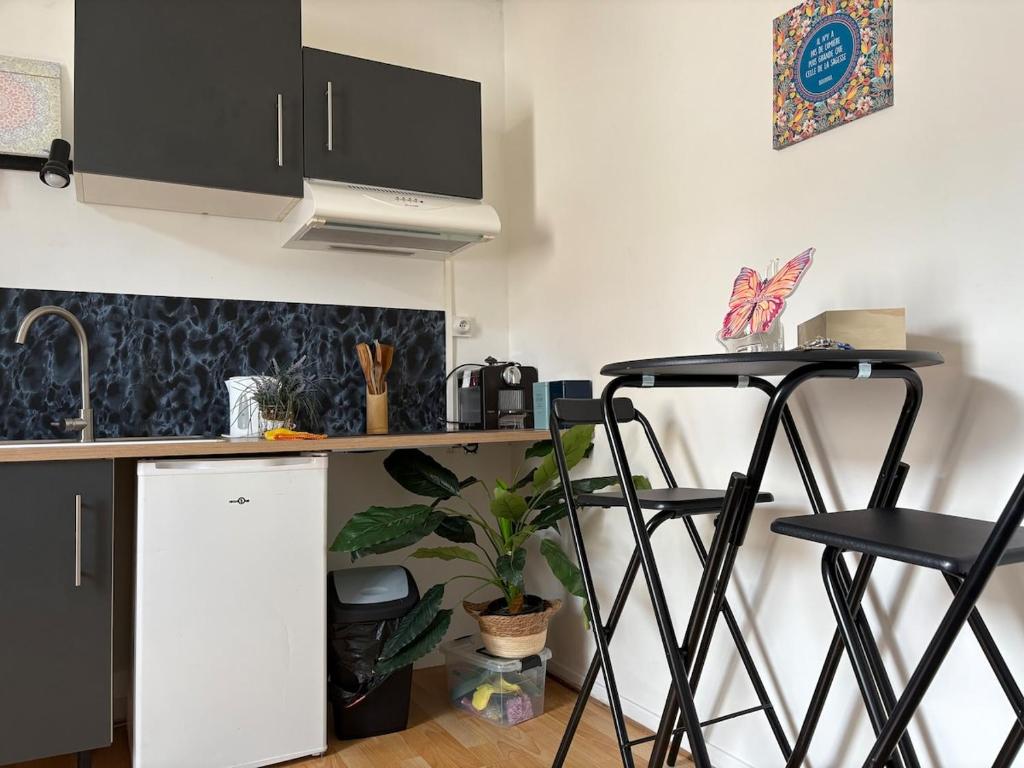 a kitchen with two bar stools and a counter at petit studio atypique in Graulhet