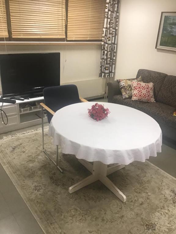 a living room with a white table and a couch at Hyryntie 33 as 3 in Hyrynsalmi