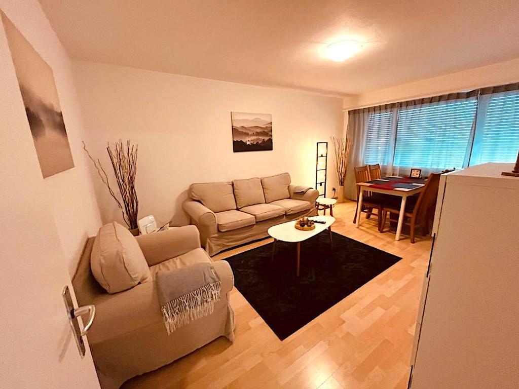 a living room with a couch and a table at 3-Room Apartment Up to 5 Guests Family Business Free WiFi Netflix Sky DAZN Disney Plus 1000 International TV Channels in Wynau