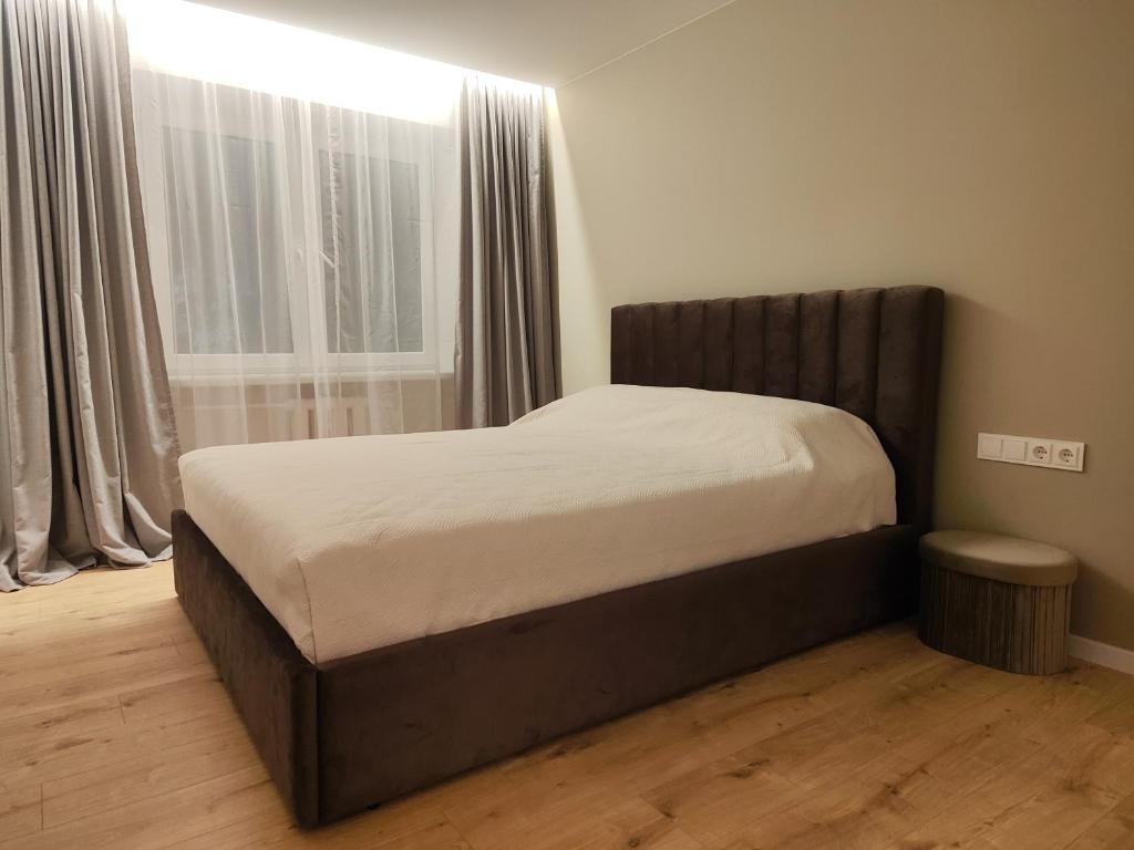 a bed in a bedroom with a large window at Manere commoda in Šiauliai