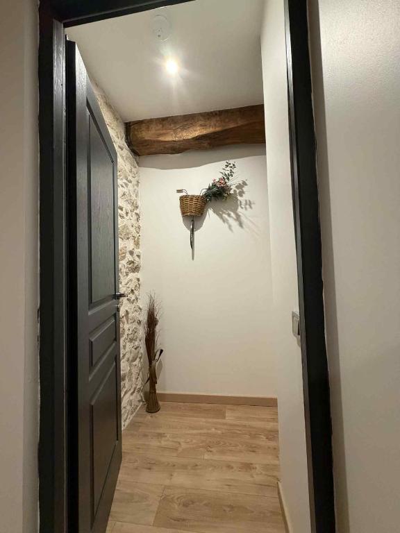 a hallway with an open door with a wreath on the wall at Au rêve de Fadi in Bruch
