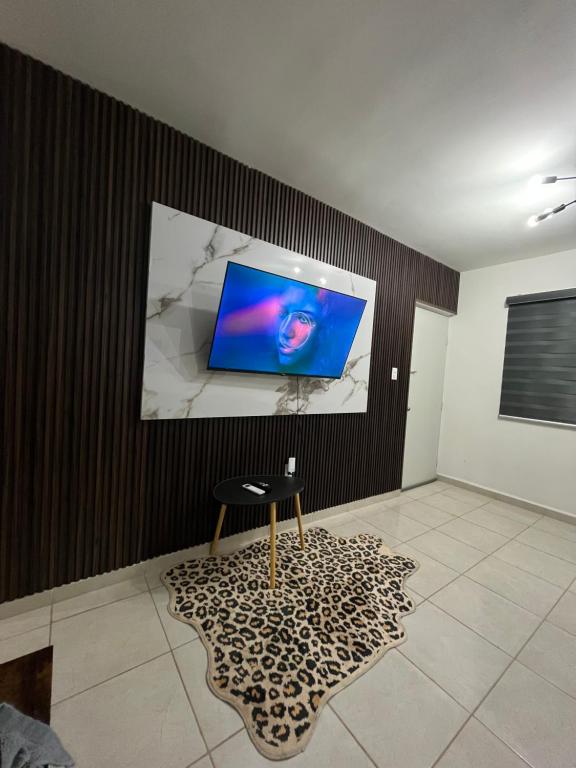 a room with a television on a wall with a stool at Noir Beach Suite in Ciudad Madero