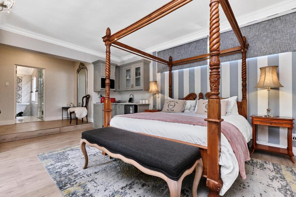a bedroom with a canopy bed and a living room at Frnch on 2nd - Sandton in Johannesburg