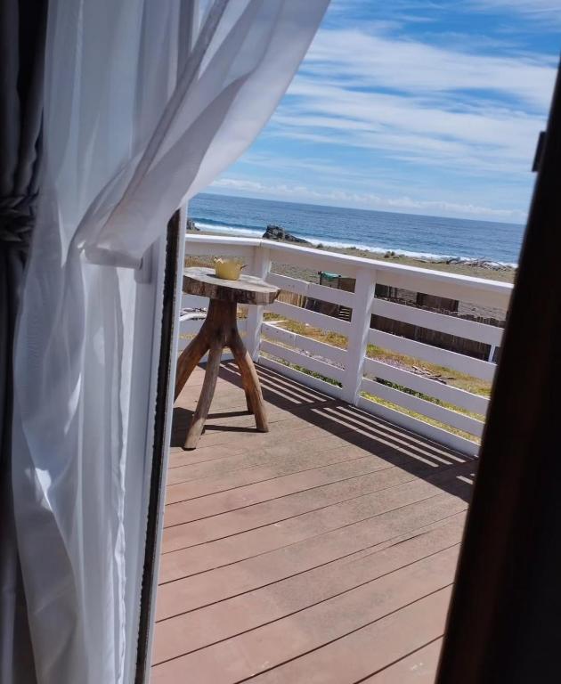 a table on a deck looking out at the ocean at Casa playa Pullay in Pullay