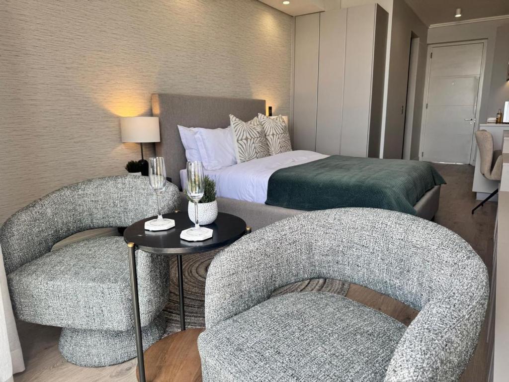 a hotel room with two chairs and a bed at Unit 4913 - Ellipse Waterfall in Midrand