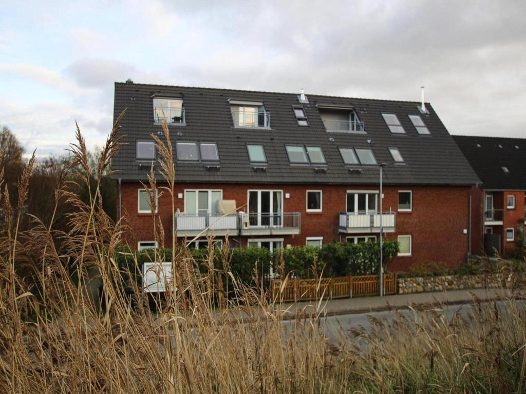 a red brick building with a black roof at Ferienwohnung, St Peter - Ording in Böhl