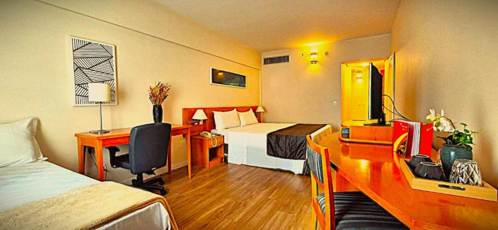 a hotel room with a bed and a desk at SOL FLAT 1805 Alphaville Hotel & Residence in Barueri