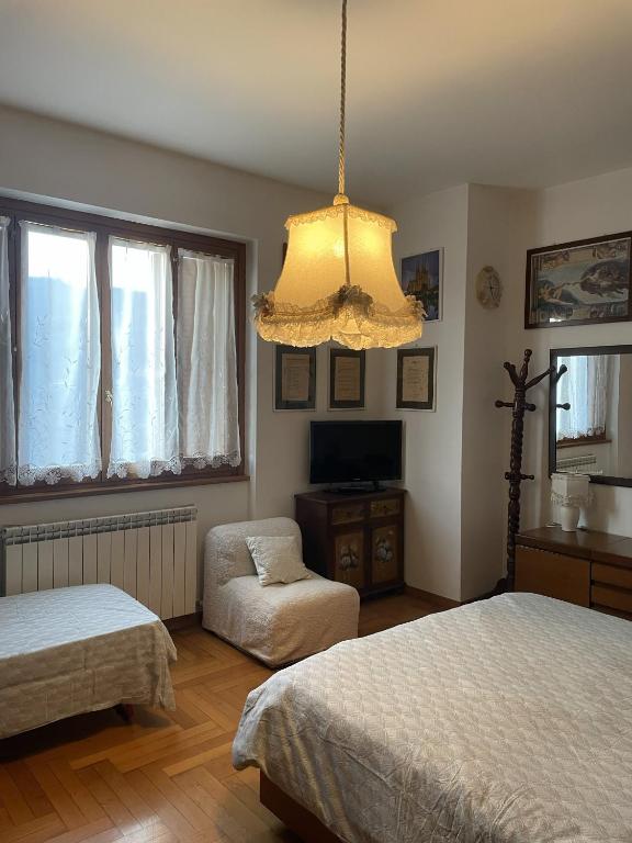 a bedroom with two beds and a chandelier at Oasi Gioia verde in Vescia