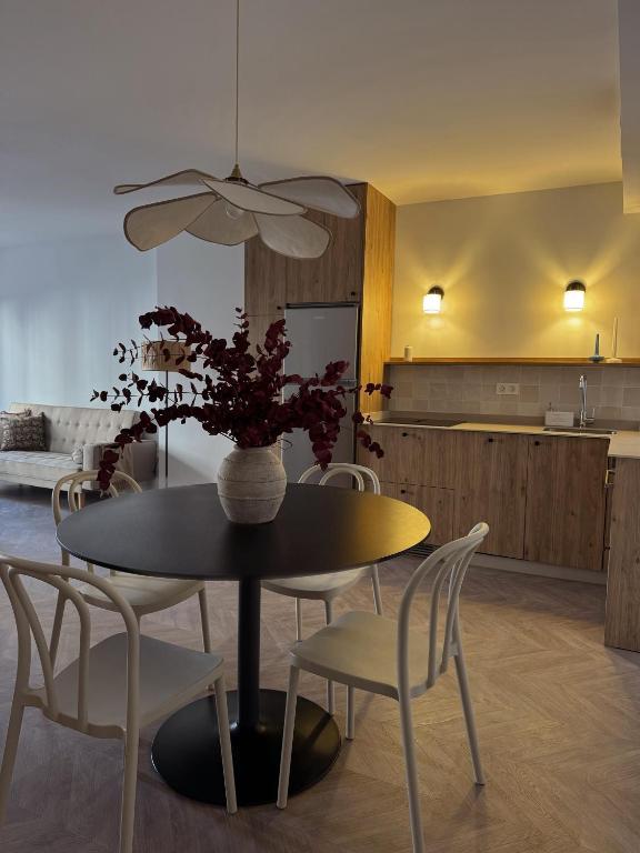 a dining room table with chairs and a vase with flowers at Hurtado Siete in Jaén