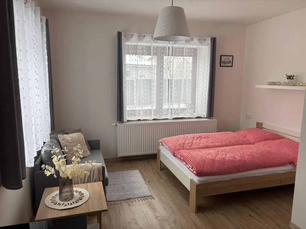 a bedroom with a bed and a table and a window at V Talutě in Chyšky