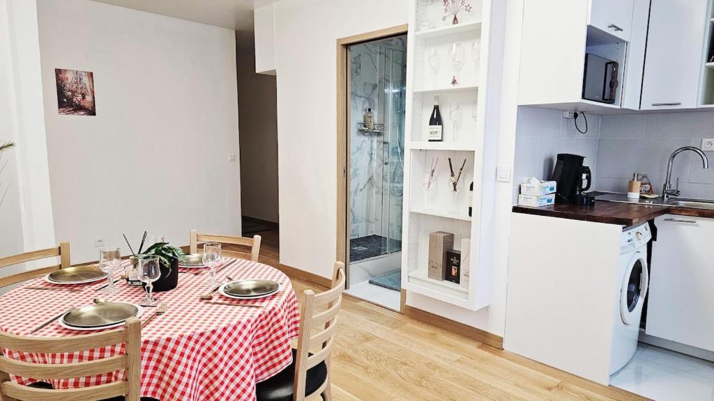 a kitchen and a table with a red and white table cloth at Nice apt with parking free in Paris