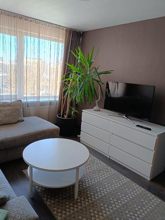 a living room with a tv and a coffee table at Cietokšņa 64 in Daugavpils