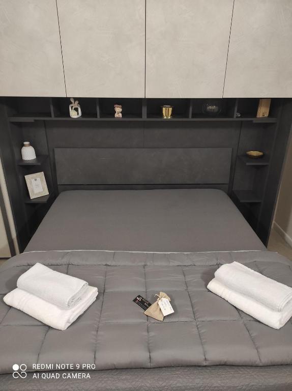 a bed with two towels and a remote control on it at B&B Delle Rose in Orta Nova