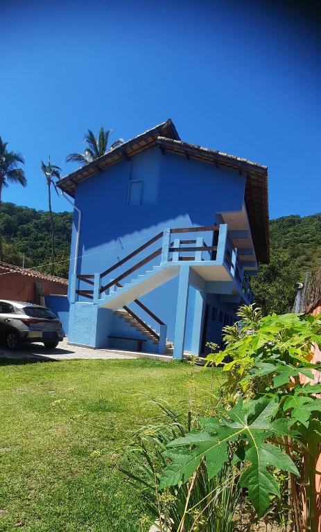 a blue house with a staircase leading up to it at Morro do Forte in Guarujá