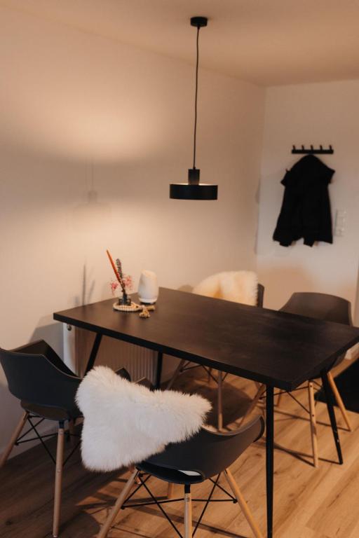 a dining room with a black table and chairs at Appartment 1 Frau Isi in Mellrichstadt