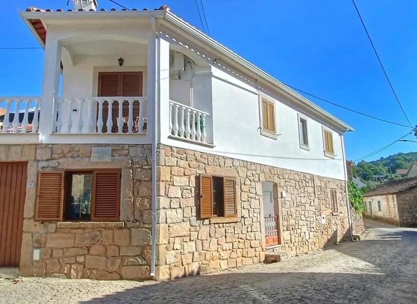 a stone building with a balcony on top of it at Casa Duas Fontes in Capinha