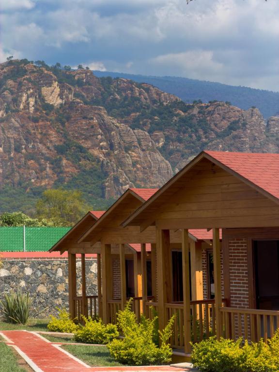 a row of houses with mountains in the background at Cabañas Tlaxomolco in Tepoztlán
