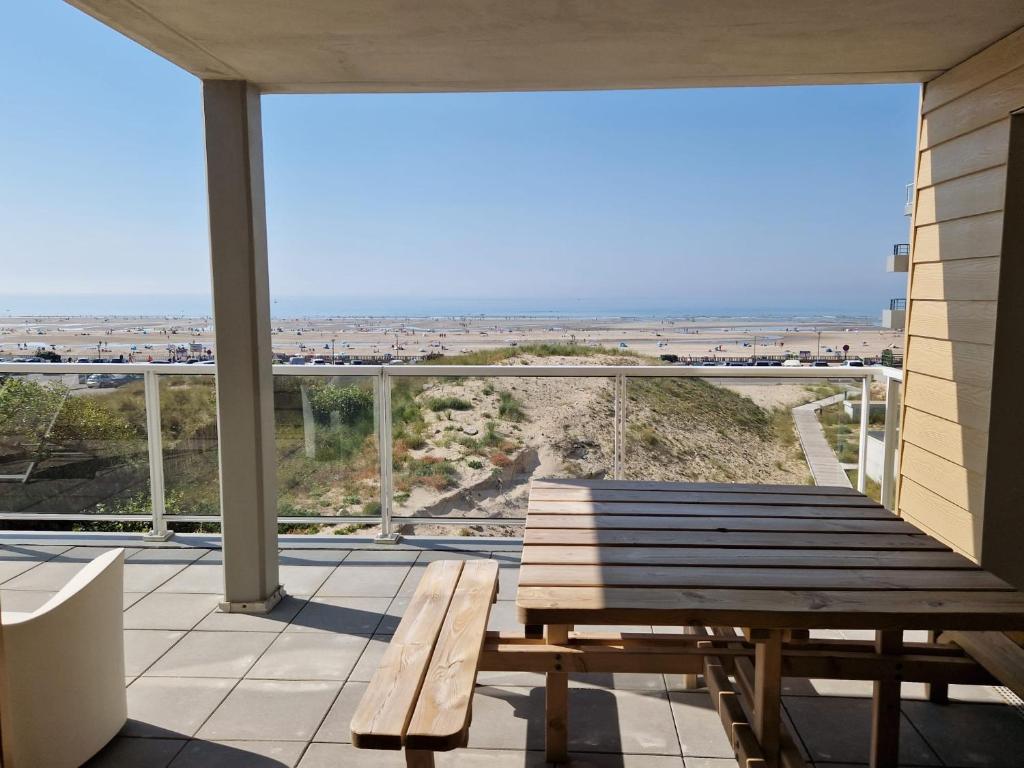 a bench on a balcony with a view of the ocean at L'effet Mer de Stella in Stella-Plage