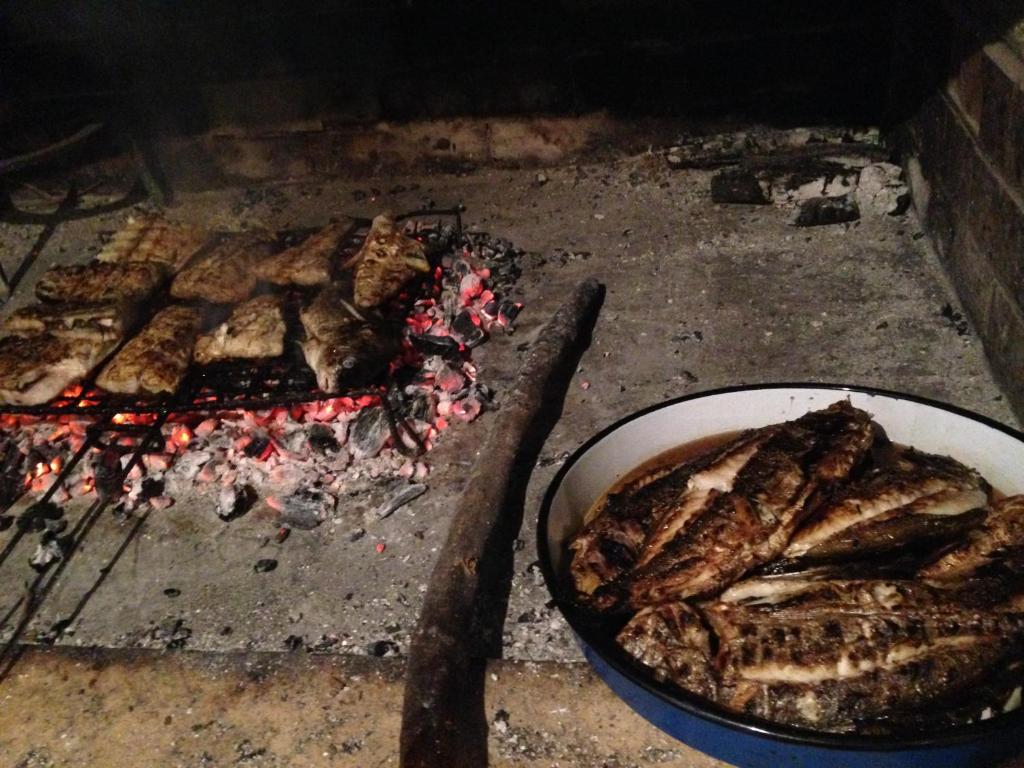 a grill with a pan of food and a bowl of meat at Apartments Luna in Žuljana