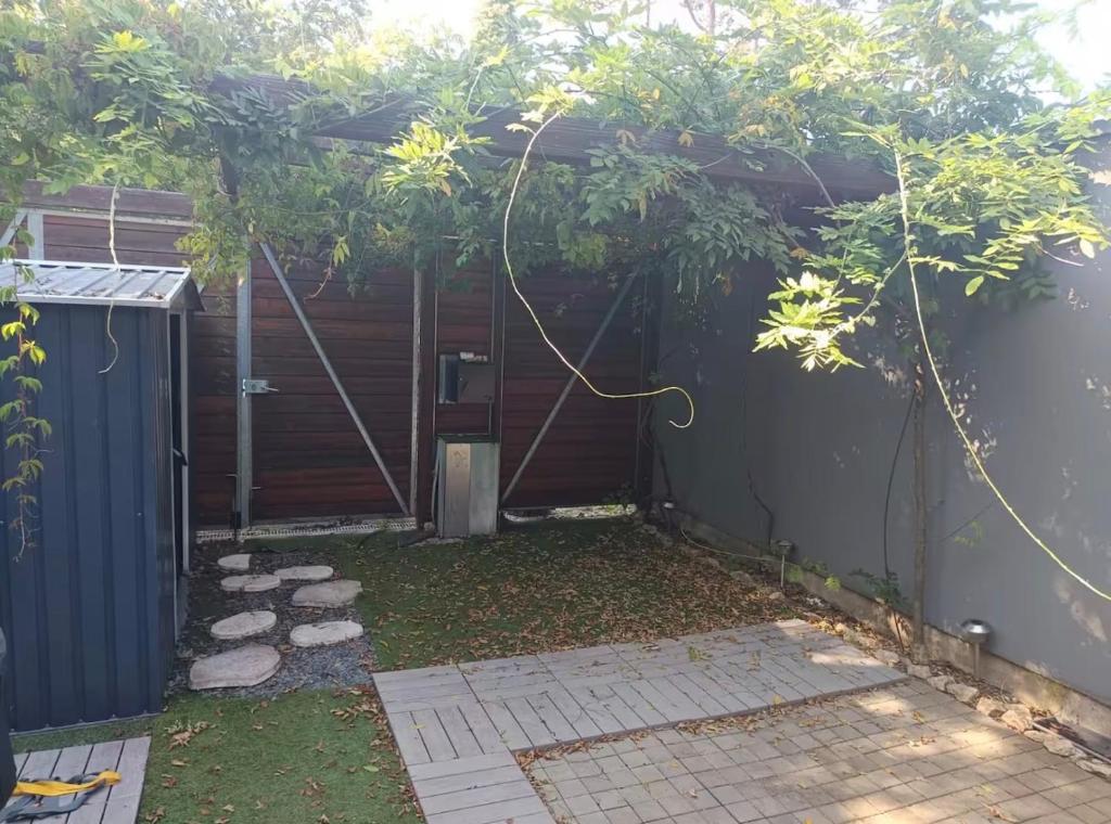 a backyard with a pergola and a fence at Chambre proche Zénith et Centre ville in Nancy