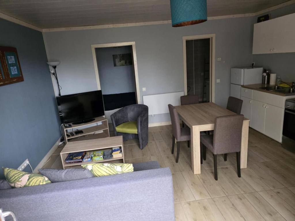 a kitchen and a living room with a table and a couch at Les deux écureuils in Vresse-sur-Semois