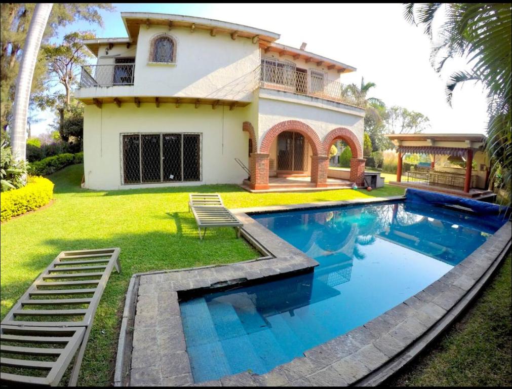 a house with a swimming pool in front of a house at Casa Grande Lomas de Cocoyoc in Texcalpan
