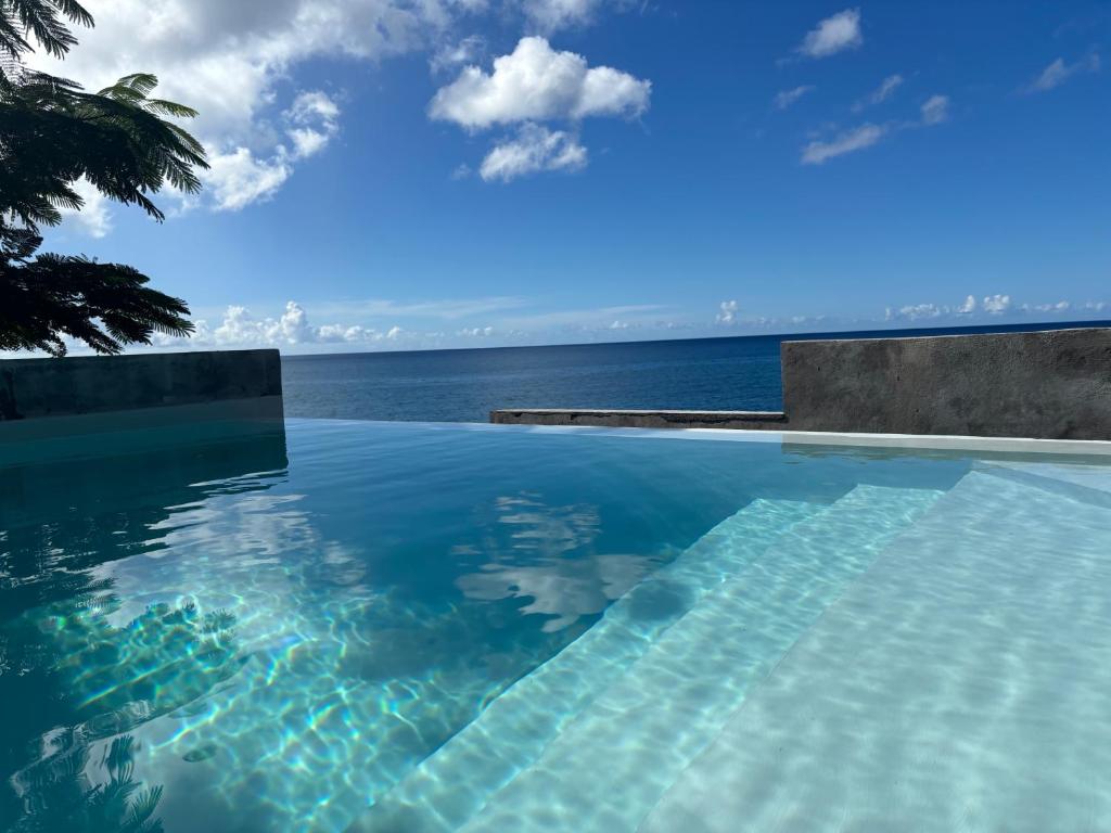 a swimming pool with a view of the ocean at Villa exceptionnelle en bord de mer - SUNSET VILLA in Pointe-Noire