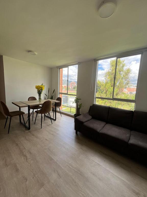 a living room with a couch and a table at Apartamento familiar de 3 habitaciones con parqueadero en Paipa in Paipa