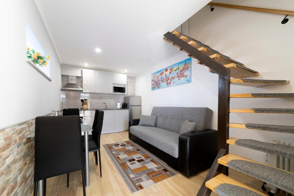 a living room with a staircase and a kitchen at Modern Duplex Close to the Beach in Armação de Pêra
